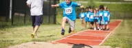 Child jumping in the long jump competition