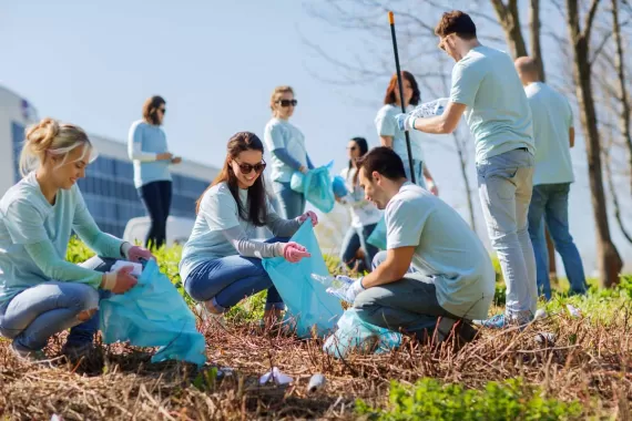 A group of people volunteering by picking up trash