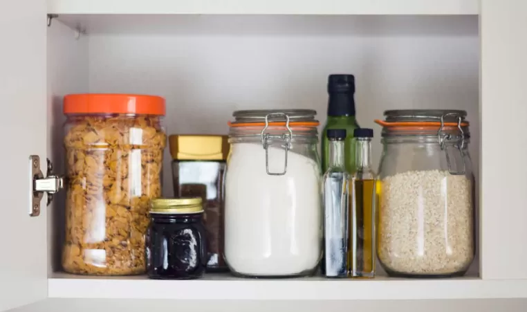 An open cabinet full of grains and oils