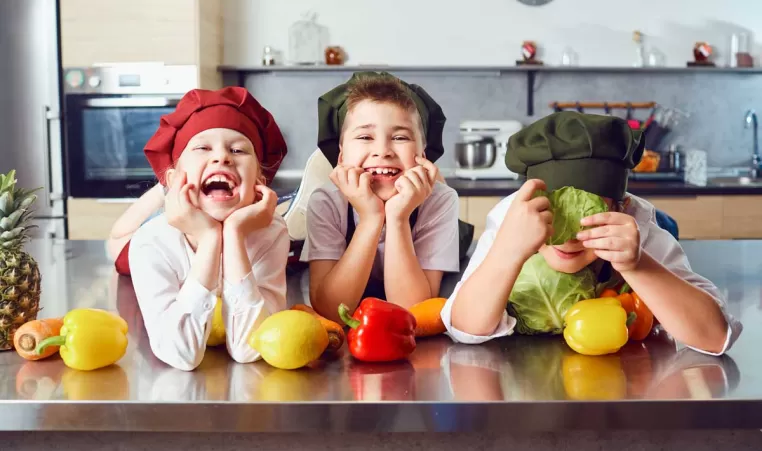 Three kids on kitchen counter laughing.