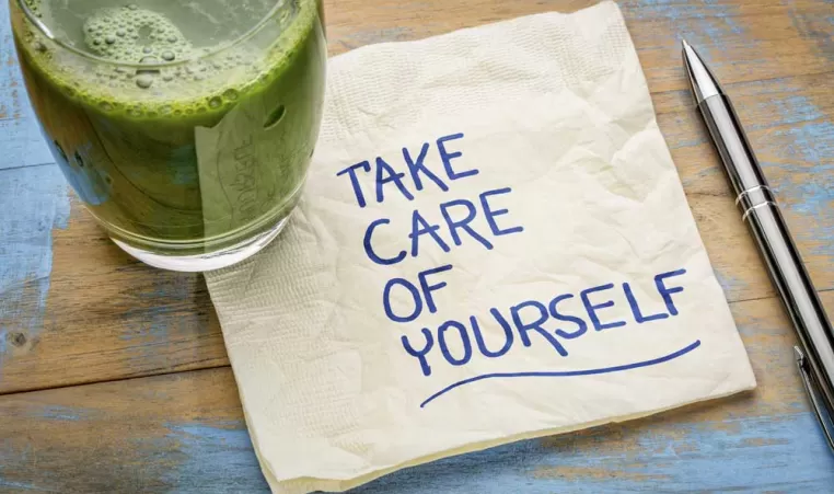 A glass of juice with a napkin that says Take Care of Yourself on it