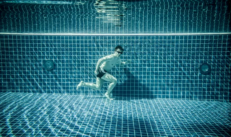 Man runs underwater swimming pool