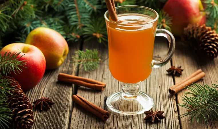 Hot apple cider traditional winter season drink with cinnamon and anise. Homemade healthy organic warm spice beverage. Christmas or thanksgiving holiday decoration on vintage wooden background