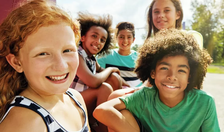 Kids sitting outside smiling