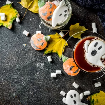 A cup of red hot chocolate with ghost marshmallows in it.