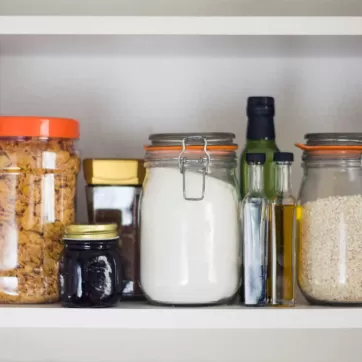 An open cabinet full of grains and oils
