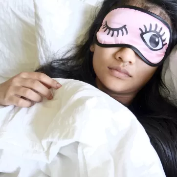 A woman sleeping with an eye mask on