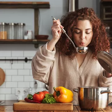 A woman cooking chili in her kitchen
