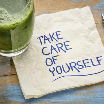A glass of juice with a napkin that says Take Care of Yourself on it