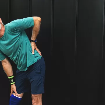 Senior man suffering with lower back pain during workout
