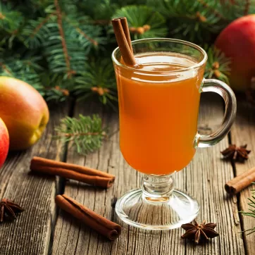 Hot apple cider traditional winter season drink with cinnamon and anise. Homemade healthy organic warm spice beverage. Christmas or thanksgiving holiday decoration on vintage wooden background