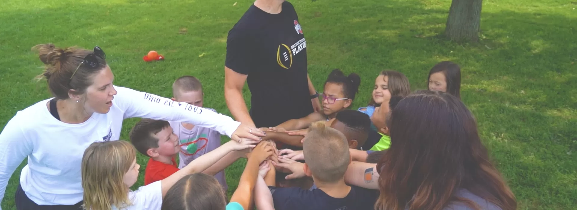 Kids at Y on The Fly group huddle hands in circle cheer