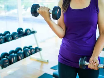 A woman in the gym lifting small weights