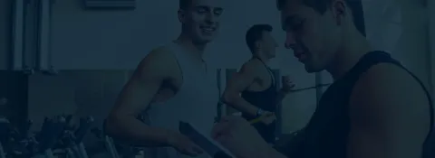 man running on treadmill as personal trainer assists and takes notes